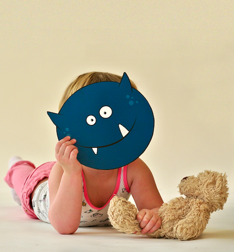 Photography of child holding monster mask (graphic design by SBP)